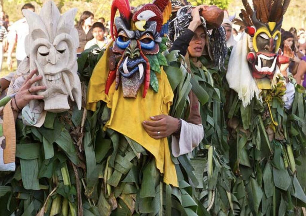 Boruca dancers wearing carved wooden devil masks performing during Fiesta de los Diablitos.